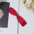 Détail de la barrette à double nœud en satin rouge avec boucle centrale en strass - Rouge