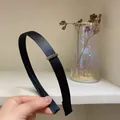 Detail of elegant black satin headband featuring small sparkling crystal diamond inlay - Black