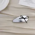 Detail of silver drop hair clip with black ribbon bow on vintage paper background - Black Bow Hair Clip
