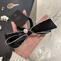 Eleganter Haargummi aus schwarzem Satin mit weißer Perle auf einer Karte - Schwarz Strass Perle