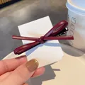 Eleganter dunkelroter Leder-Schleifen-Haarclip mit Nahtdetails auf weißer Karte - Kunstleder / Burgunderrot
