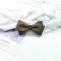 Macro detail of brown wool bow hair clip with a vintage rectangle grey gemstone center - Woolen / Brown