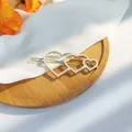 Cute golden hair clip featuring triple overlapping hearts with inlaid white pearls - Heart