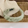 Chic sage green lace padded headband with handmade label in a rustic woven basket - Light Green Plaid