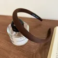 Detalle de diadema de tela marrón con etiqueta hecha a mano sobre frasco de perfume - Cuadros Marrón Oscuro
