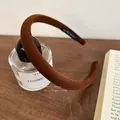 Primer plano de diadema acolchada marrón con etiqueta artesanal sobre tela acanalada - Cuadros Café Oscuro