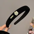 Detail of black velvet headband with white camellia flower and gold metal logo plaque - Narrow Edge Style (A395) / Black