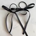 Elegante schwarze Satin-Haarschleifen mit langen Bändern auf Marmor im 2er-Set - Schwarz Fein Satin / Haargummi