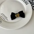 Detail of black velvet bow hair tie with a gold heart pendant and silver bead accents - Hair Clip / Black