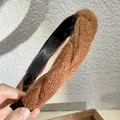 Gros plan du bandeau en laine marron montrant la texture douce et le détail torsadé - Café