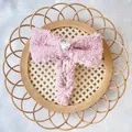 Stijlvolle pluche roze strik haarclip met hartvormige strass op een geweven dienblad - Roze