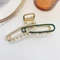 Detail van een grote gouden haarklem van legering met crème en donkergroene emaille afwerking - Groen