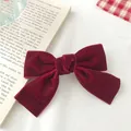 Detailed close-up of a vintage dark red velvet bow hair clip on a classic book background - Burgundy Small Style