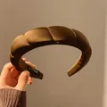 Dettaglio del cerchietto imbottito in raso bronzo con etichetta fatta a mano - Treccia Café