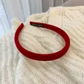 Close-up of red velvet headband with hand-made label on a knitted sweater background - Velvet Red