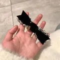 Détail du nœud papillon en velours noir avec bordure en tweed et emblème doré - Noir