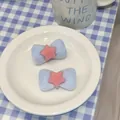 Detail of soft blue velvet bow hair clips with pink star on a white porcelain dish - Blue Pink Star
