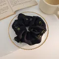 Dettaglio scrunchie vintage in tulle nero con rosa e fiocco verde su vassoio - Rosa 3D (Nero) / Nero