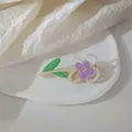 Detail shot of a purple floral duckbill hair clip with pearls on a ceramic plate - Purple Flower