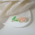 Detail of pink flower hair clip with pearls on a textured white display background - Pink Flower