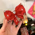 Detail van rode satijnen strik haarklem met een sprankelend hart van strass in het midden - Rood
