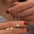 Dettaglio ravvicinato del set di gioielli a cuore in oro lucido con collana e orecchini - Set Collana e Orecchini a Bottone Cuore Oro (6342401HB)