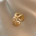 Dettaglio dell'anello a più strati dorato con nodo e zirconi cubici scintillanti - Oro - Croce a più strati in zirconia