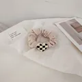 Close-up of pink scrunchie with heart checkerboard charm on a white artistic background - Beige Heart