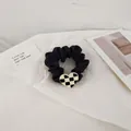 Detail of satin scrunchie featuring a black and white checkerboard heart metal charm - Black Heart