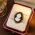 Vista macro de un broche camafeo vintage con perfil de mujer en un marco de oro fino - Blanco