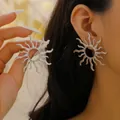 Exaggerated silver sunburst earrings featuring radiant streamline rays and hollow center - Sunburst Radial Style (2690) / Silver