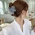 Pince à cheveux élégante en dentelle fleurie bleu clair et blanc sur un chignon bas - Bleu clair
