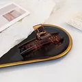 Elegant amber tortoiseshell hair claw clip for women on a vintage tray with spring - Caramel color