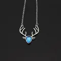 Macro detail of silver deer pendant with blue teardrop crystal on black mirror surface - Silver with Lake Blue