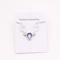 Close-up of silver reindeer antler necklace with a purple teardrop gem on display card - Light Purple
