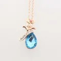 Détail d'un collier en or rose avec pendentif rose et cristal bleu en forme de goutte - Or Bleu