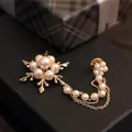 Goldene Schneeflocken-Brosche mit Perlen und Fransenketten auf edler dunkler Geschenkbox - Gold Schneeflocken Perlen Brosche Set Mit Kette