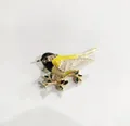 Broche de pájaro en esmalte con plumas amarillas y detalles de cristal en rama dorada - Negro Y Amarillo Claro