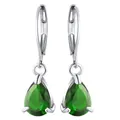 Macro detail of pear-shaped emerald drop earrings with silver lever-back clasps - Green