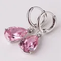 Detailed close-up of pink teardrop crystal earrings with silver-tone claw setting - Pink