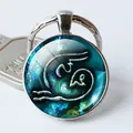 Primer plano de llavero plateado del zodiaco con cabujón de cristal azul y diseño artístico - Arte Onírico Azul Oscuro (Estilo 3)