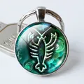 Detalle macro de llavero del zodiaco Escorpio con gema de cristal y aro metálico - Tótem de Escorpio Verde (Estilo 6)