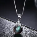 Vista macro de collar de cadena de plata con tres circonitas y colgante de perla oscura - Obsidiana