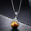 Primer plano de cadena de plata con colgante de ojo de tigre y detalles de circón brillante - Ojo de tigre
