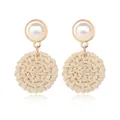 Detailed view of bohemian style earrings featuring large pearls and woven straw circles - Beige Woven Pearl Style