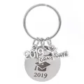 Vista macro del llavero de plata 2019 con pergamino de diploma y birrete de graduado - Set de Birrete y Pergamino Año 2019