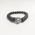 Detalle de cuentas negras mates y dije de cabeza de león plateada en esta pulsera de hombre - Cabeza de León Plateada / Plata antigua