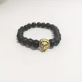 Detalle de pulsera de cuentas negras mate con adorno de cabeza de león dorada - Cabeza de León Dorada / Oro antiguo