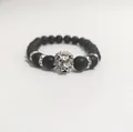 Detalle de la pulsera de cuentas negras mate con dije de cabeza de león plateado y strass - Plata antigua