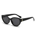 Stijlvolle zwarte cat-eye zonnebril met goudkleurige metalen accenten op de poot - Zwart Frame Grijze Lenzen
